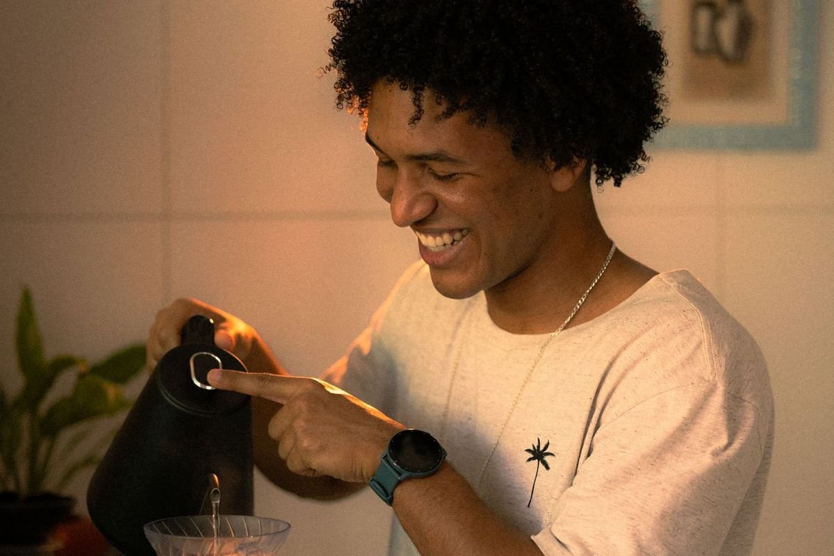 Smiling man brewing pour-over coffee in his kitchen