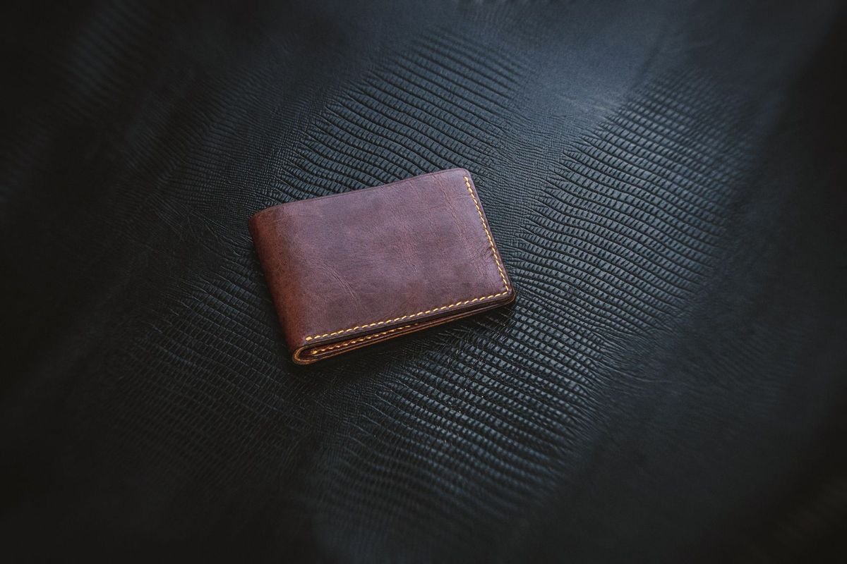 Minimalist brown leather wallet on a textured background (representative photo, not the exact product)