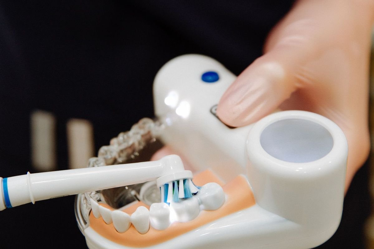 Electric toothbrush shown on a dental model (representative photo, not the exact product)