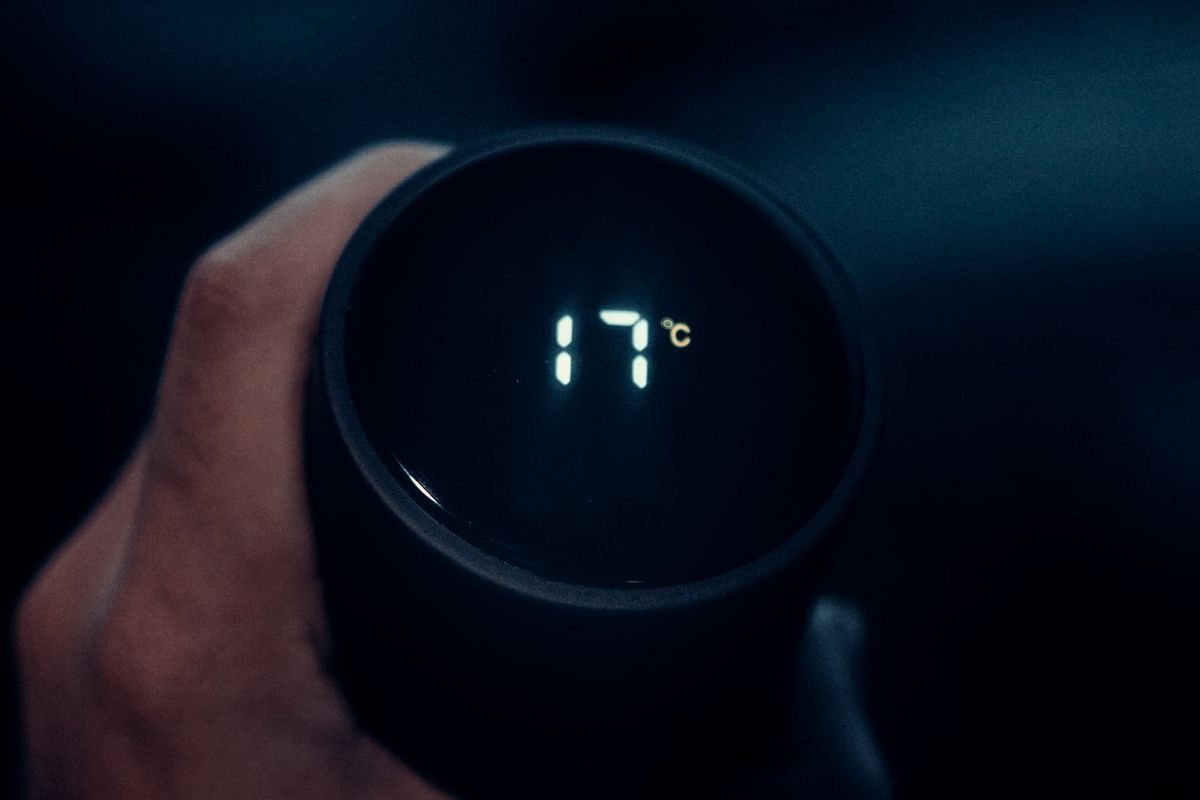 Man holding a smart thermos cup with a temperature display (representative photo, not the exact product)