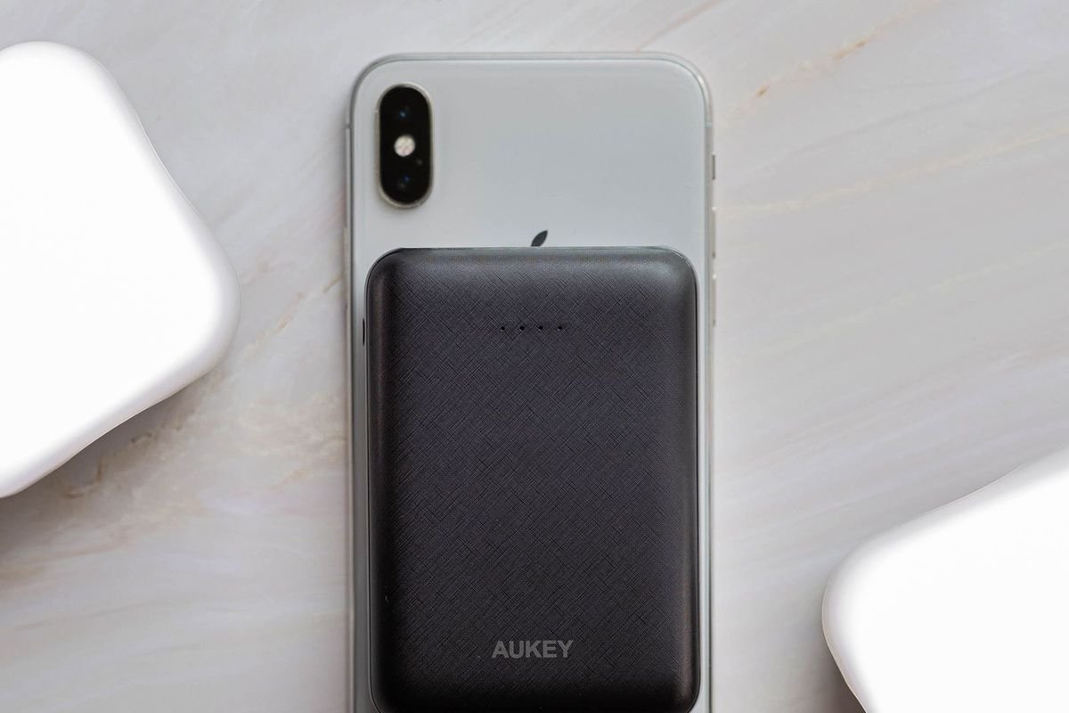 Compact black power bank attached to the back of a smartphone on marble (representative photo, not the exact product)