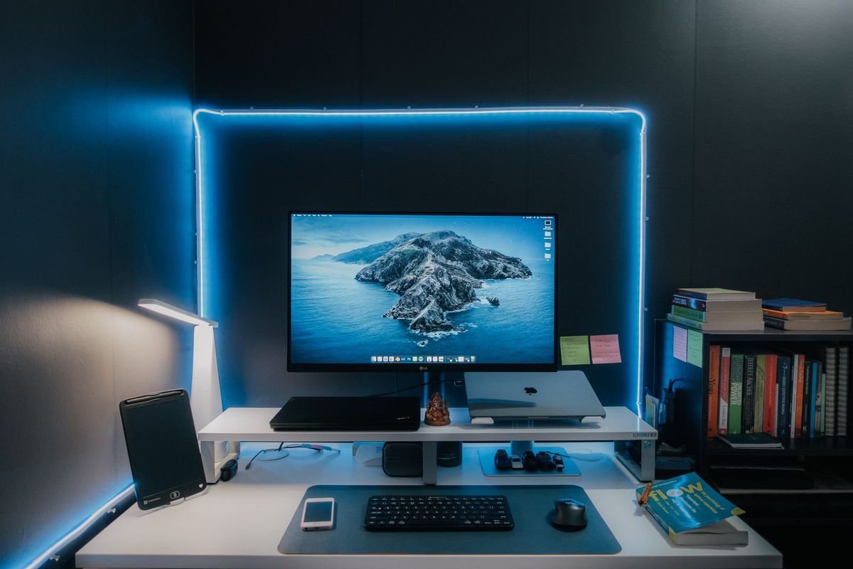 Home office desk with a monitor, keyboard and LED accent lighting at night (representative photo, not the exact product)