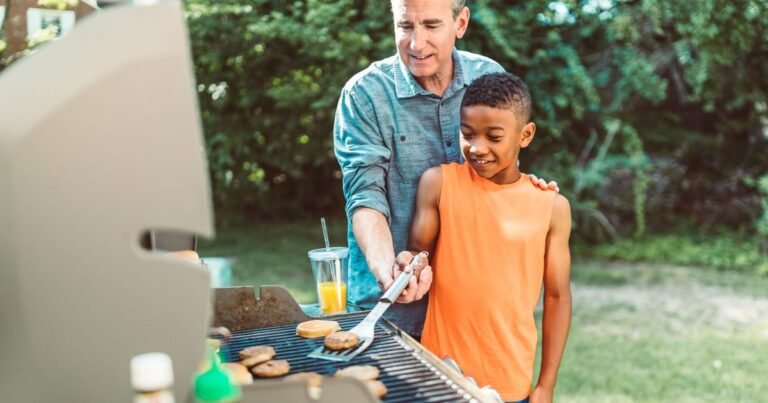 Father teaching his son to grill burgers in the backyard