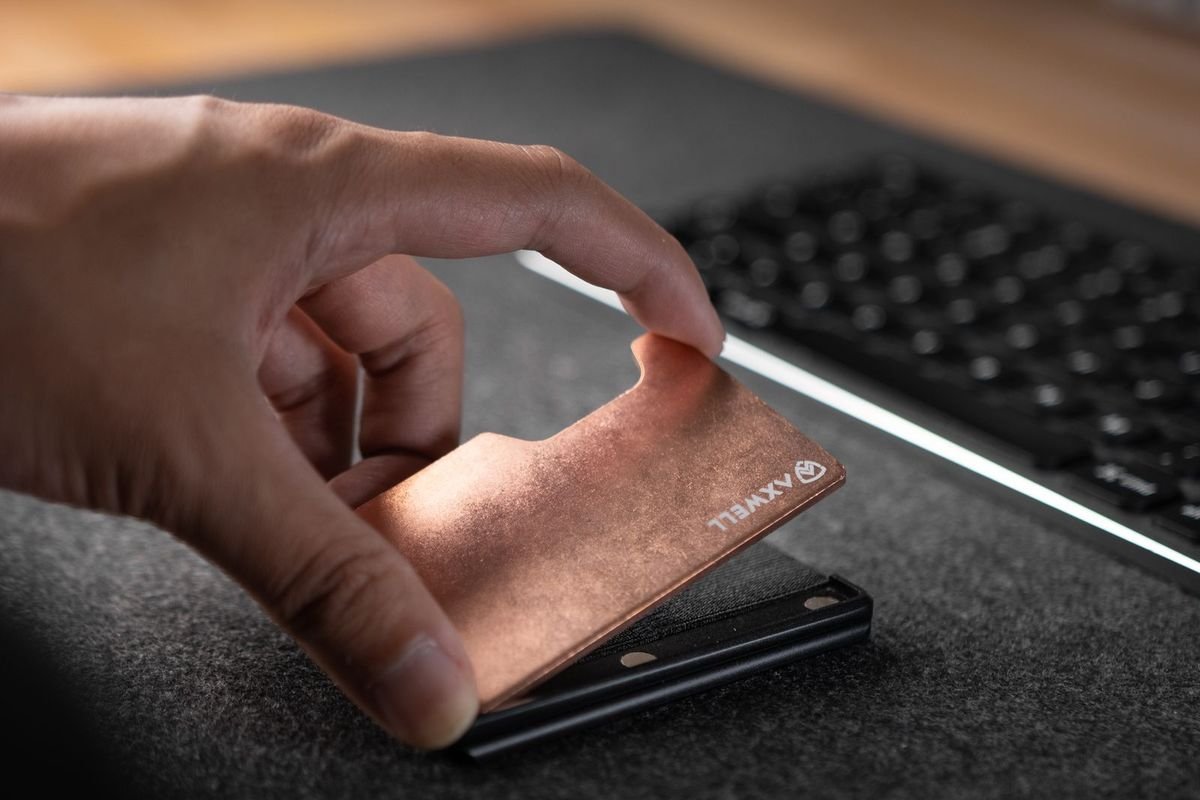 Hand holding a slim metal wallet (representative photo, not the exact product)