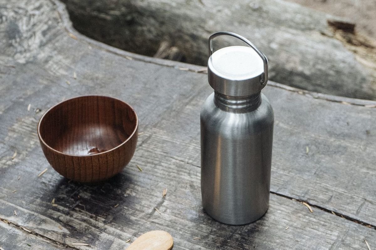 Stainless steel vacuum flask on a wooden table (representative photo, not the exact product)