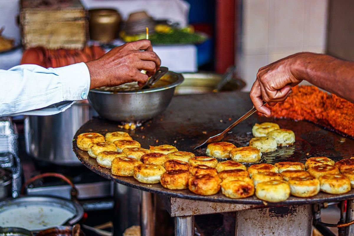 Person cooking on a flat griddle (representative photo, not the exact product)