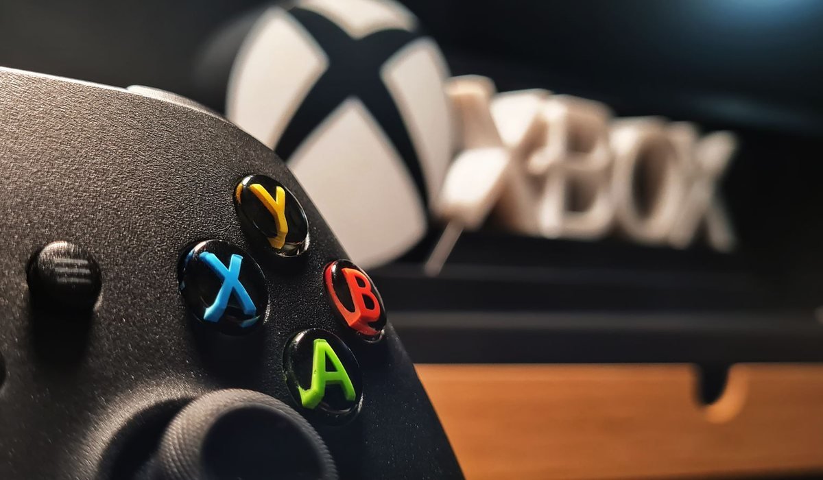 Close-up of an Xbox controller in a colorful gaming setup