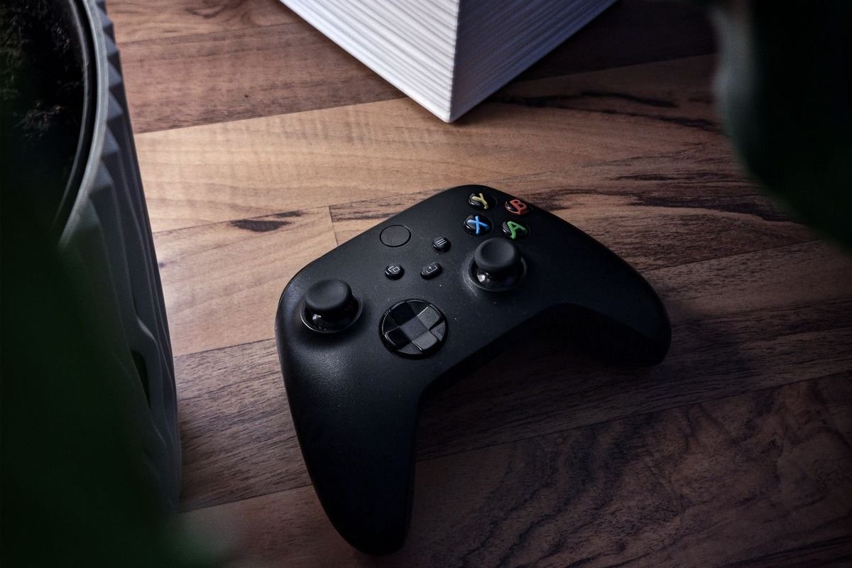 Wireless gamepad lying on a wooden desk (representative photo, not the exact product)
