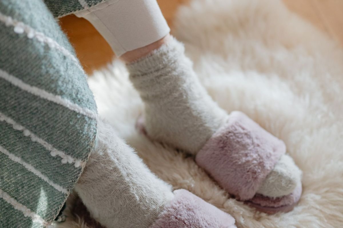 Feet in fuzzy socks and slippers on a rug (representative photo, not the exact product)