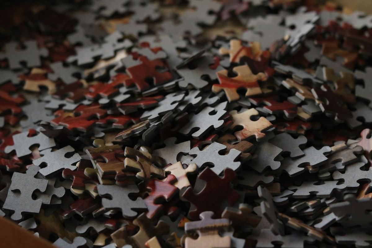 Scattered jigsaw puzzle pieces on a table (representative photo, not the exact product)