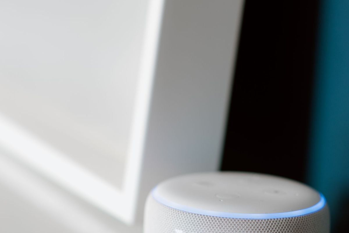 White smart speaker with a digital display on a table (representative photo, not the exact product)