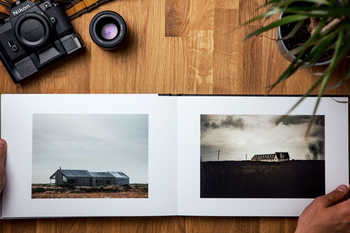 Opened photo book and camera on a table (representative photo, not the exact product)