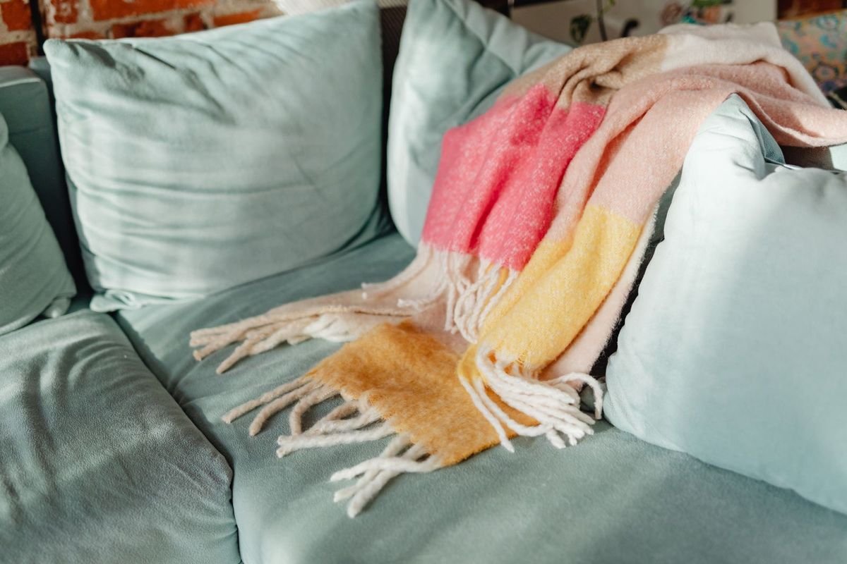 Colorful blanket draped on a teal sofa (representative photo, not the exact product)