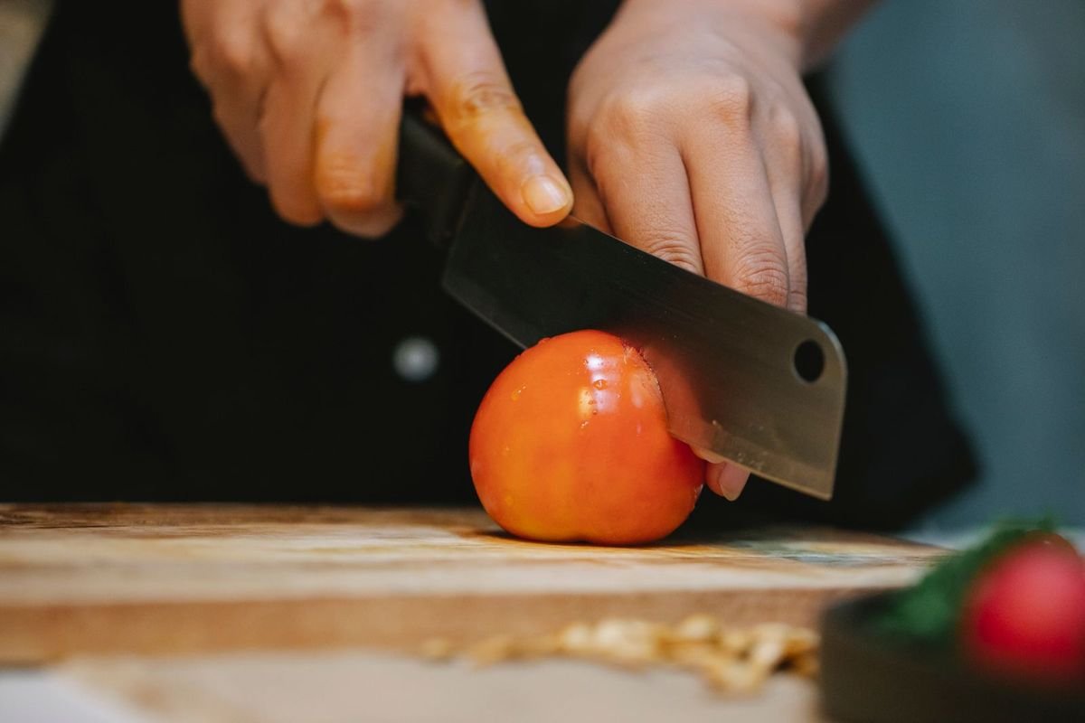 Chef slicing tomatoes on a wooden board (representative photo, not the exact product)