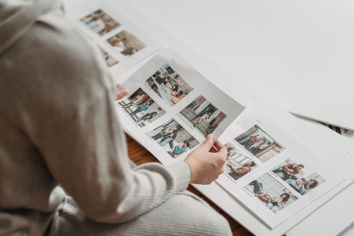 Woman looking through printed photos in an album (representative photo, not the exact product)