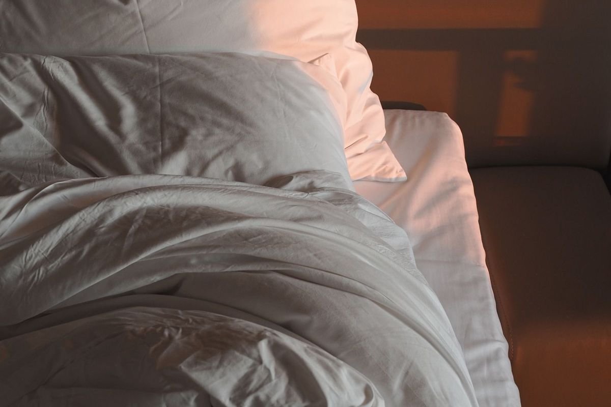 Bed with white pillows and a fluffy blanket (representative photo, not the exact product)