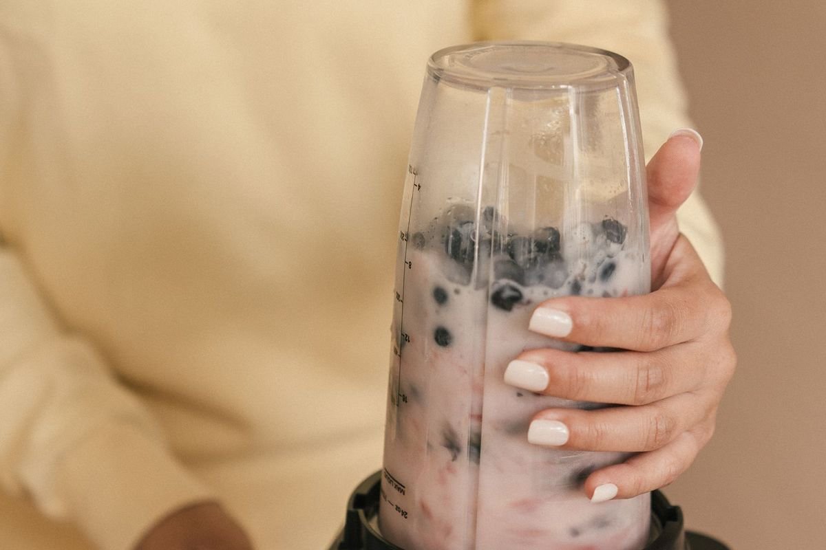 Person using a blender (representative photo, not the exact product)