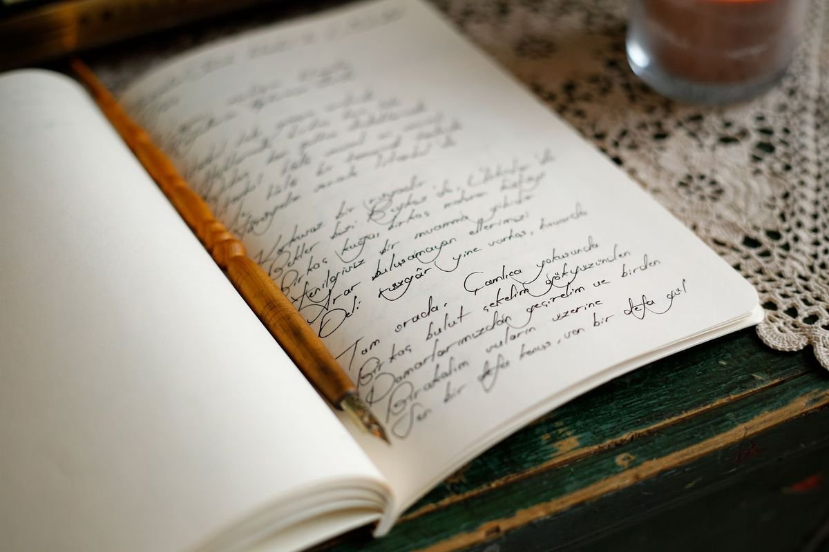 Handwritten notes in a journal with a pen (representative photo, not the exact product)