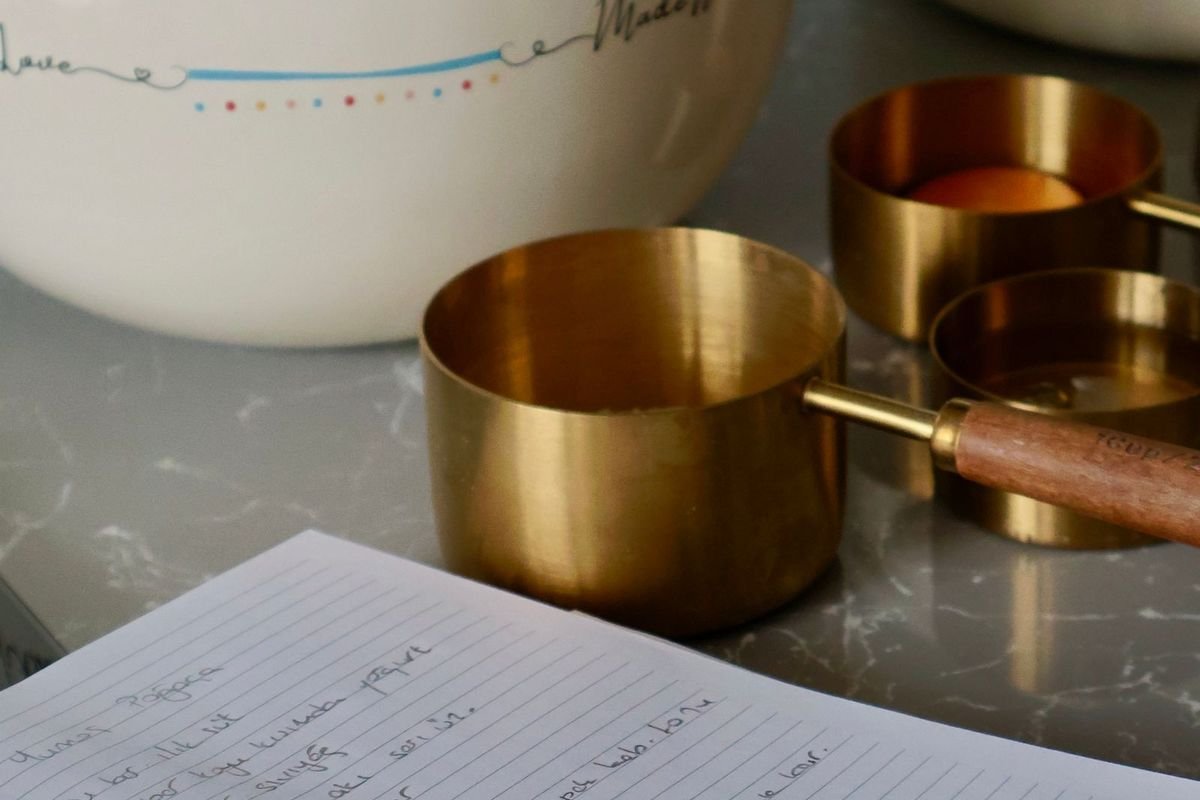 Cozy kitchen scene with a recipe notebook, measuring cups and bowls (representative photo, not the exact product)