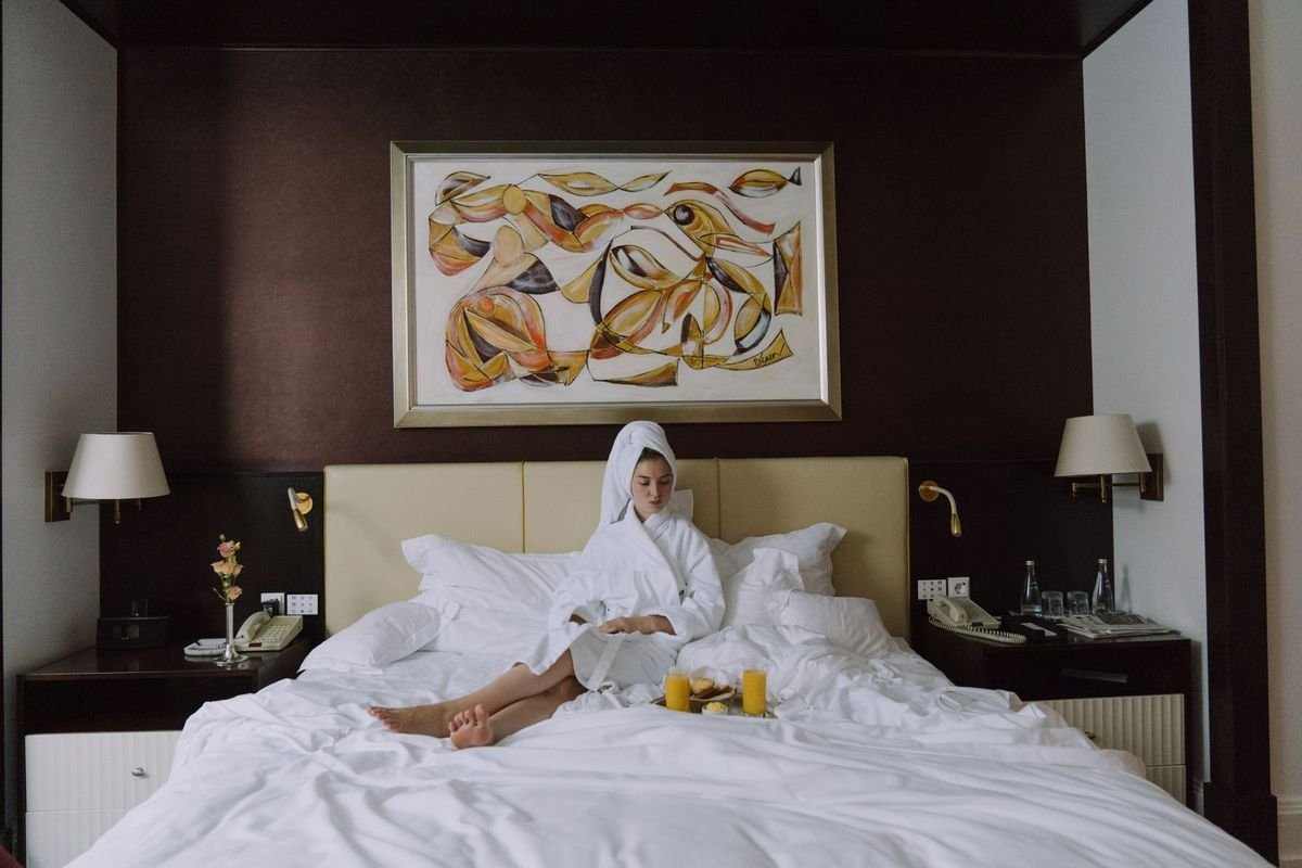 Woman in a bathrobe sitting on a bed with a breakfast tray (representative photo, not the exact product)