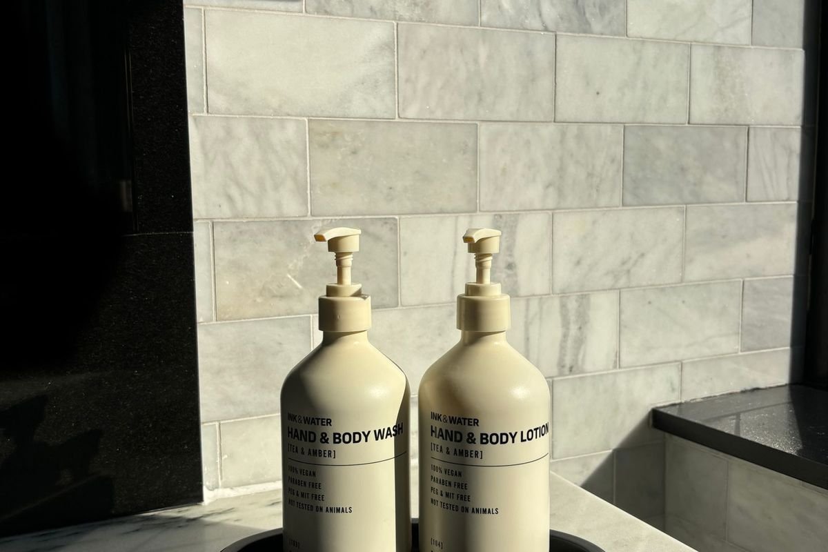 Bottles of body lotion on a tray in a marble bathroom (representative photo, not the exact product)