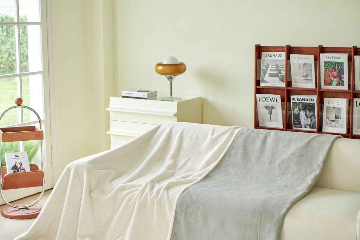 Throw blanket draped on a beige sofa in a bright living room (representative photo, not the exact product)