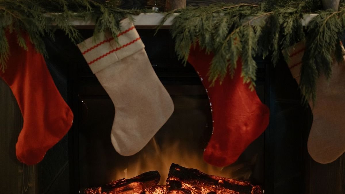 Christmas stockings hanging above a glowing fireplace