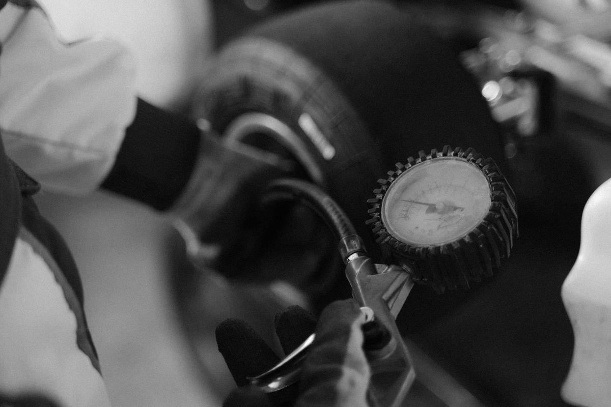 Checking tire pressure with a gauge (representative photo, not the exact product)