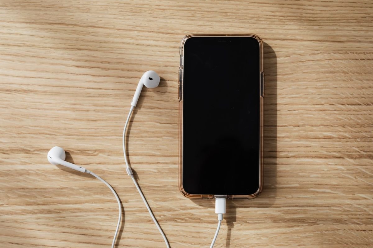 Smartphone and earphones charging on a wooden table