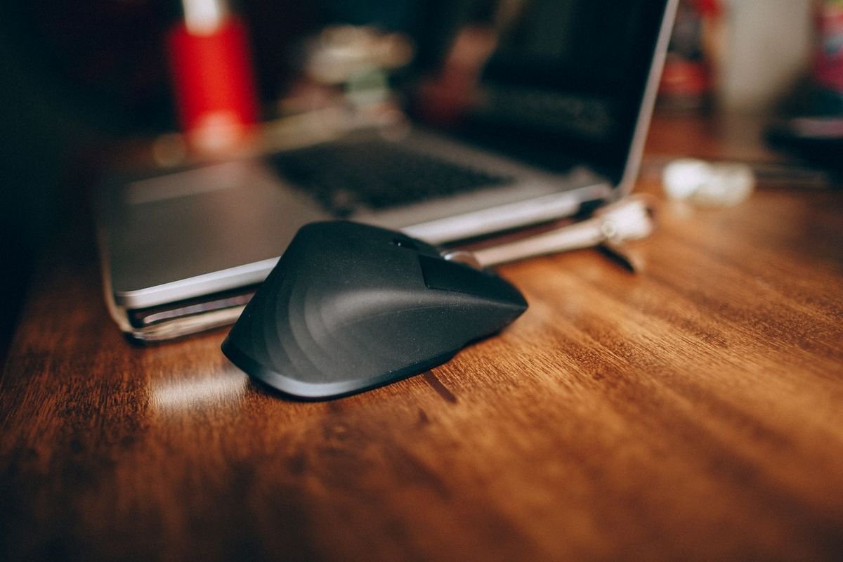 Black computer mouse on a wooden table (representative photo, not the exact product)