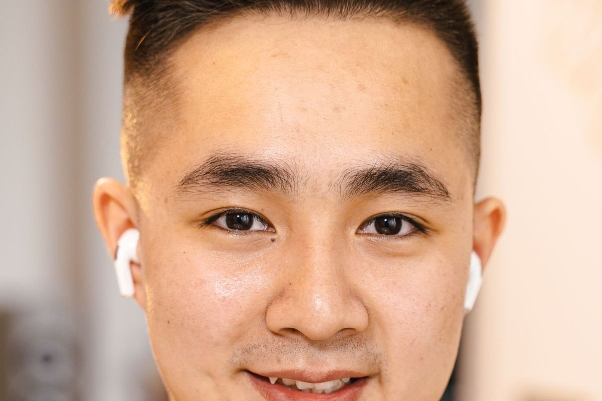 Smiling young man wearing wireless earbuds