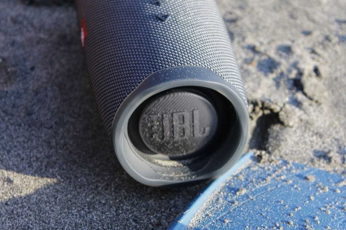 Portable speaker on a sandy beach (representative photo, not the exact product)