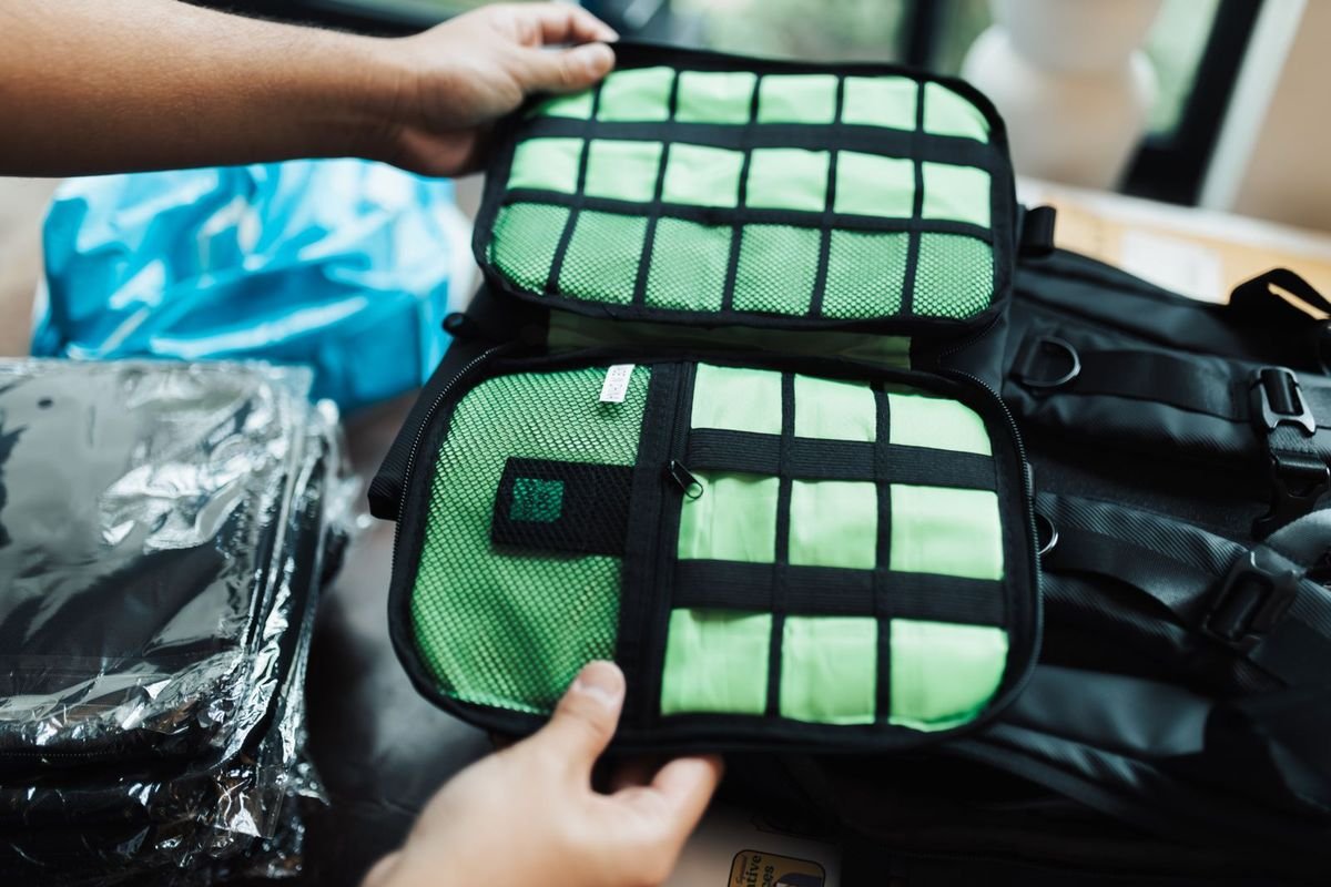 Hands organizing green packing cubes inside an open suitcase (representative photo, not the exact product)
