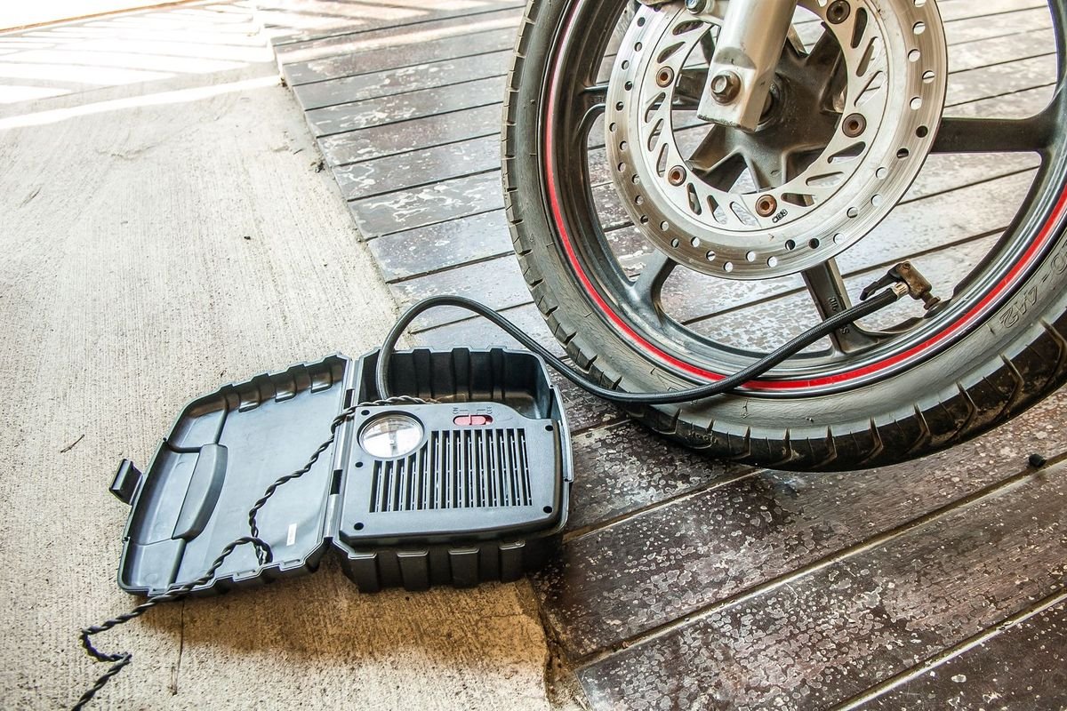 Close-up of a tire being inflated with a portable pump (representative photo, not the exact product)