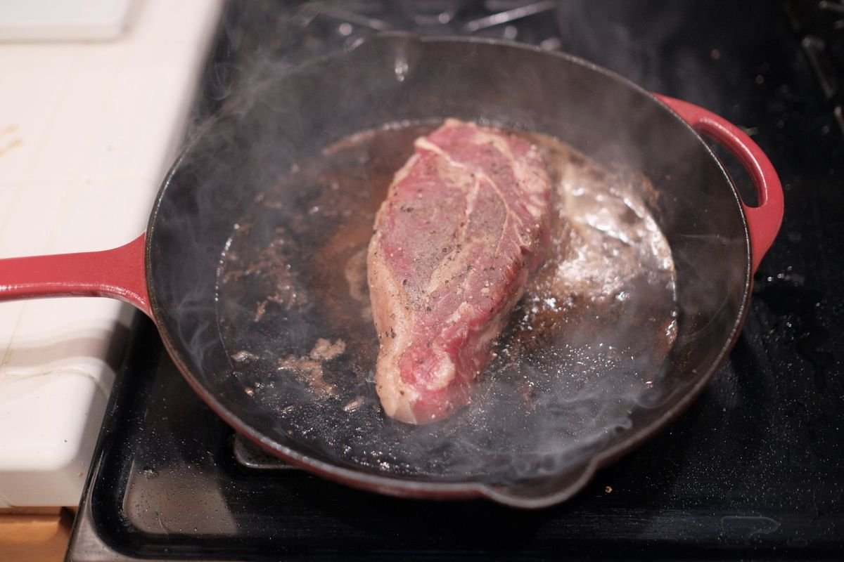 Steak cooking in a skillet (representative photo, not the exact product)