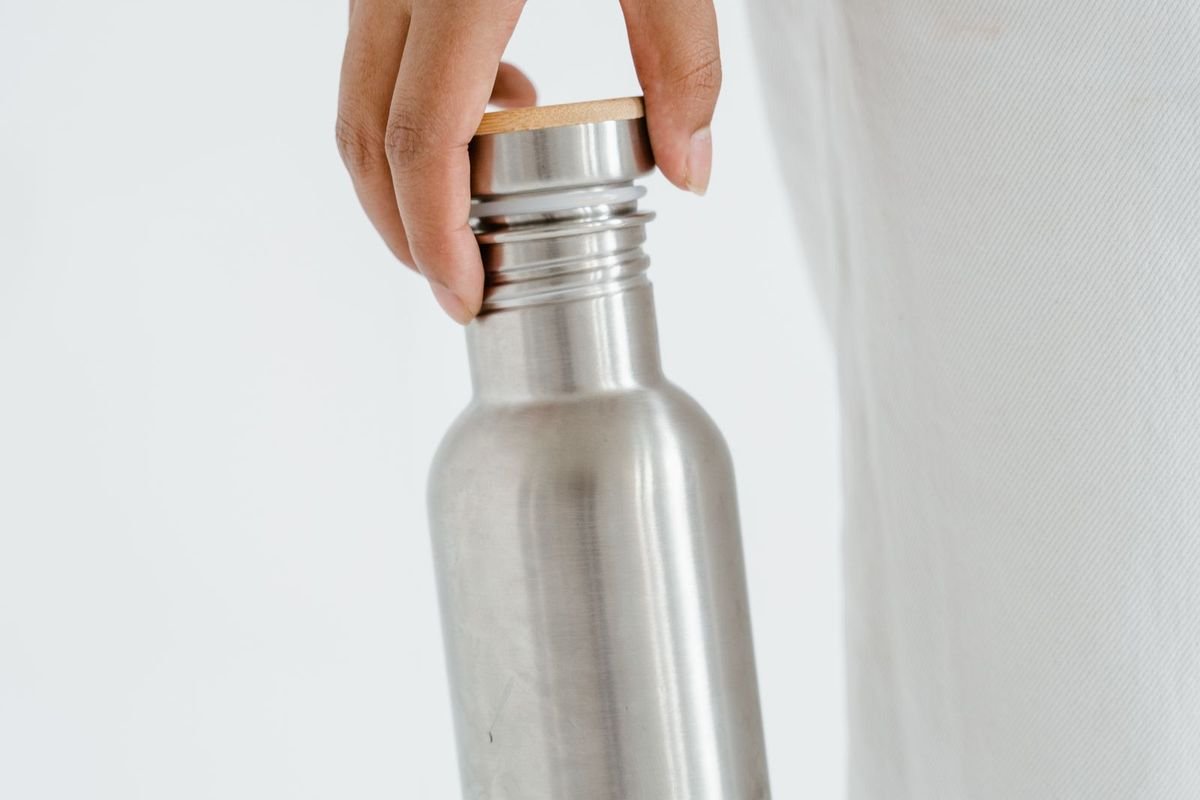 Hand holding a stainless steel bottle (representative photo, not the exact product)