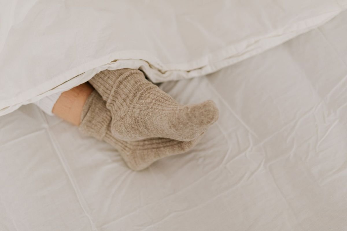 Feet in beige socks on white textile (representative photo, not the exact product)