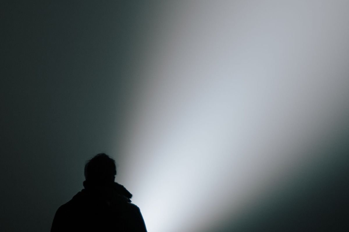 Silhouette with a flashlight beam in dense fog (representative photo, not the exact product)