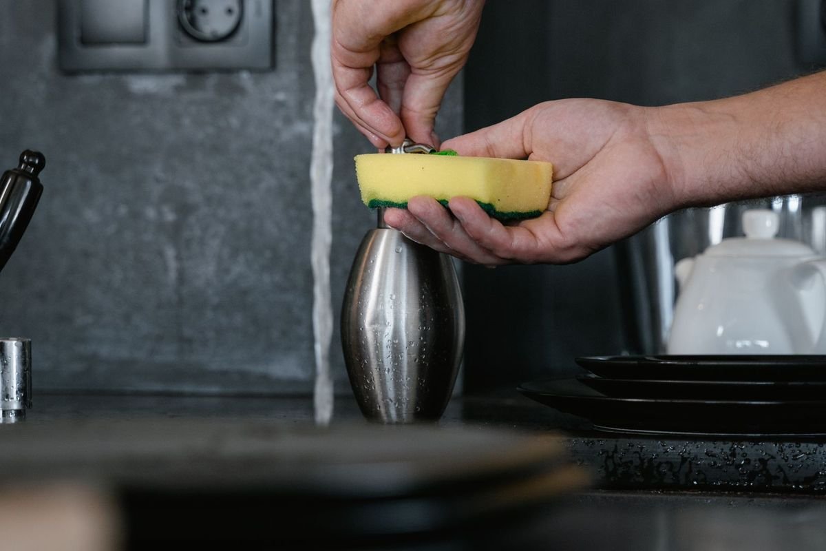 Person putting dish soap on a sponge (representative photo, not the exact product)