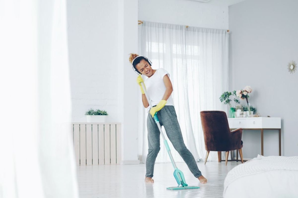 Woman cleaning her bright modern living room with a mop