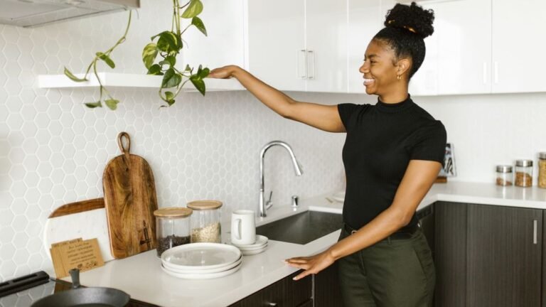 Smiling woman organizing a bright white kitchen